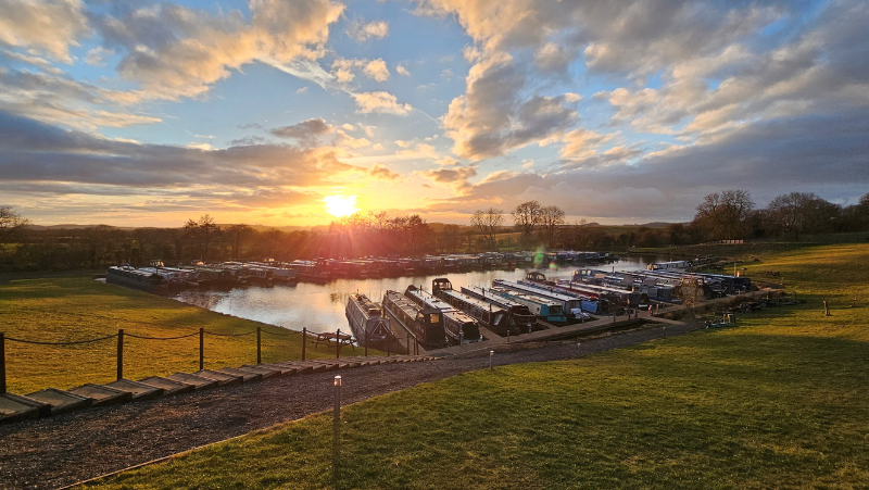 A stunning sunset over a marina of canal boats