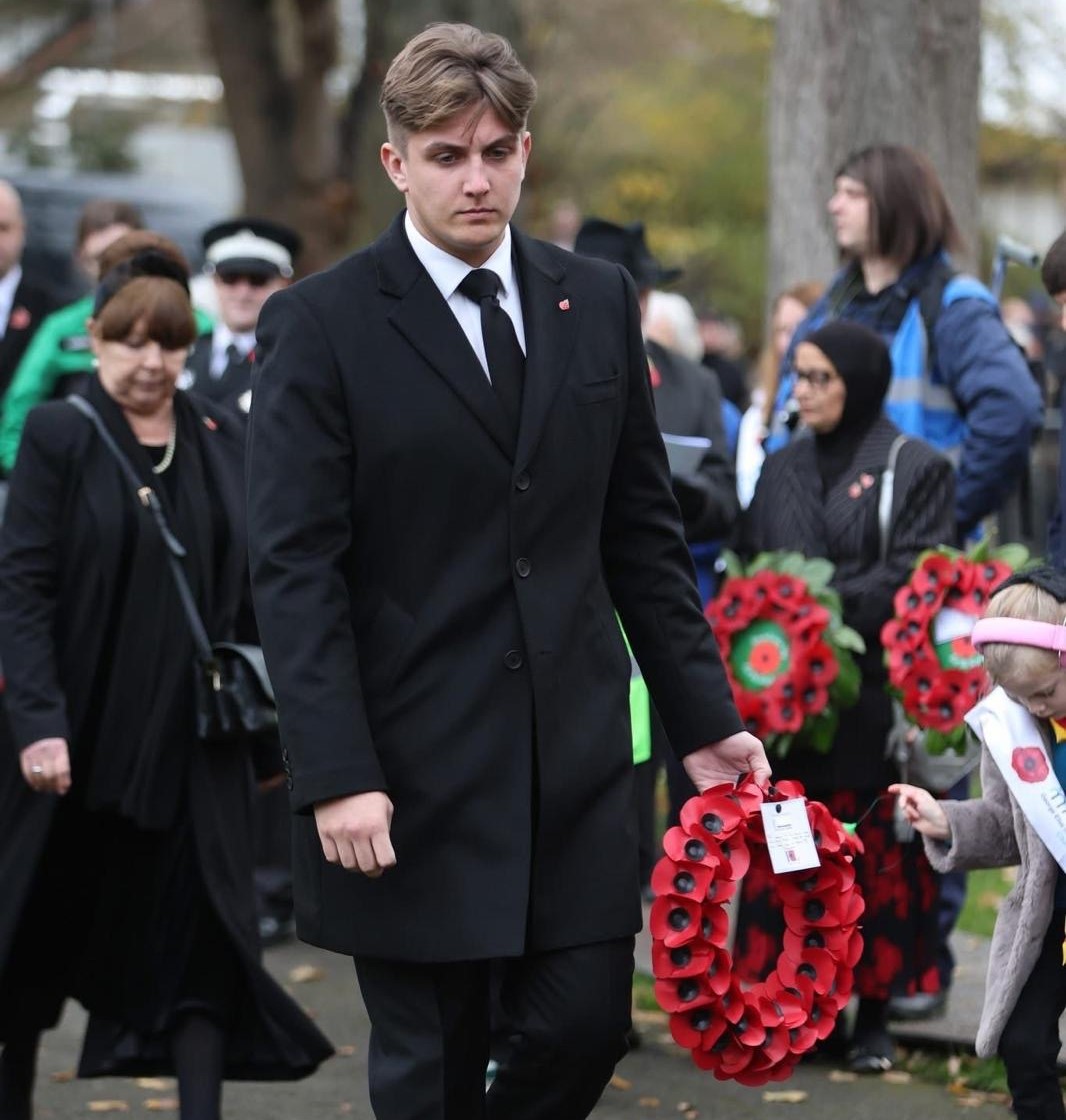 Cllr George Finch holding a remembrance wreath at the service.