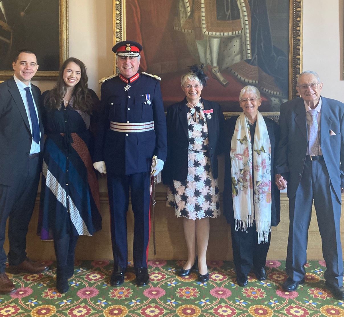 Sorrelle Clements (fourth from left) wearing her British Empire medal next to Lord Lieutenant Tim Cox alongside family and friends.