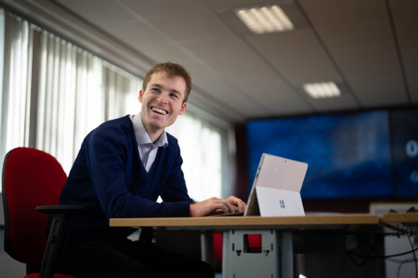 Someone looking up from their computer screen smiling