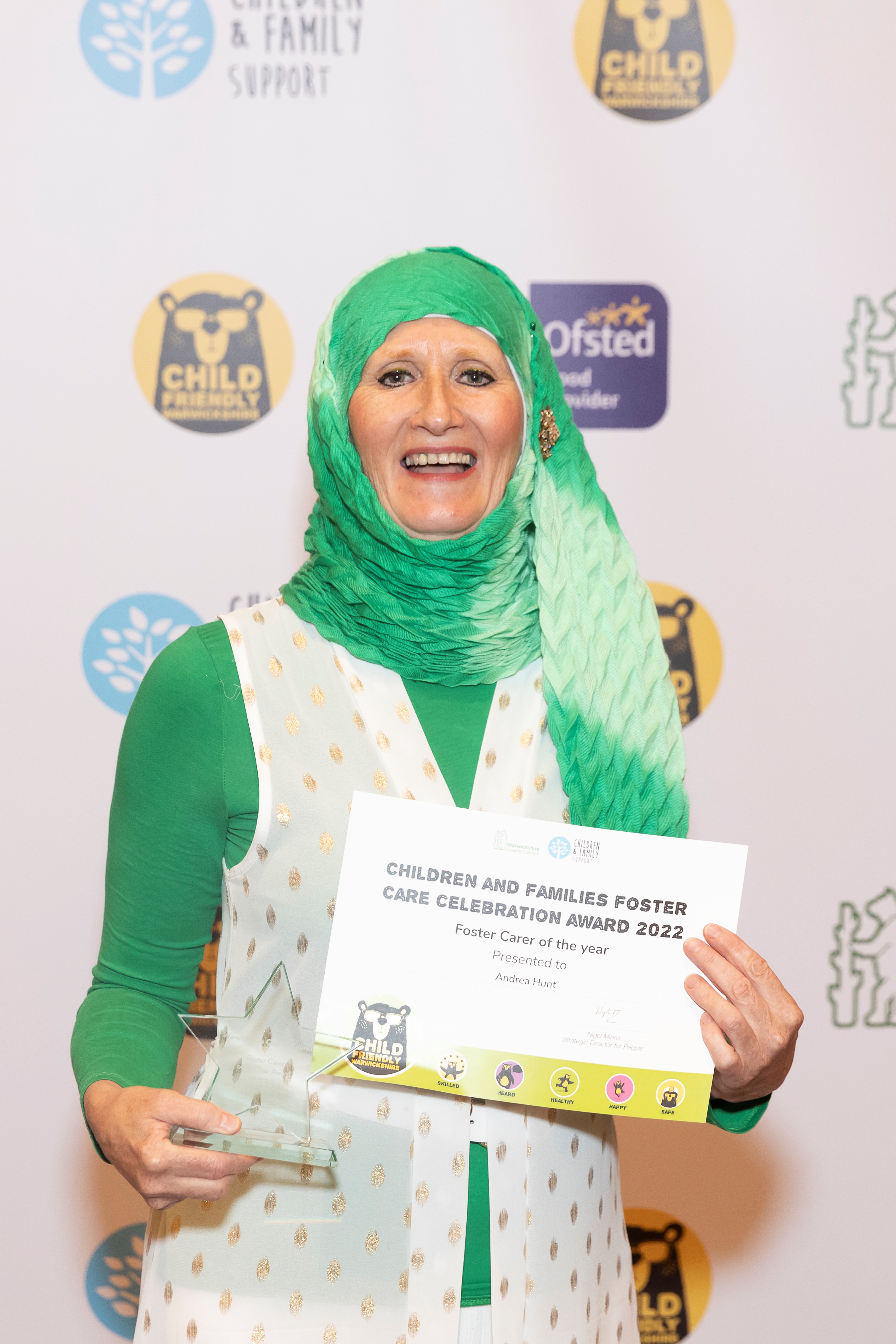 Andrea Hunt, WCC Foster Carer of the Year 2022, smiling and holding up her award and certificate
