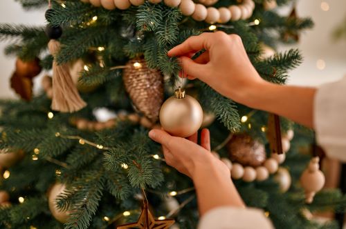 Christmas tree with person putting a bauble on