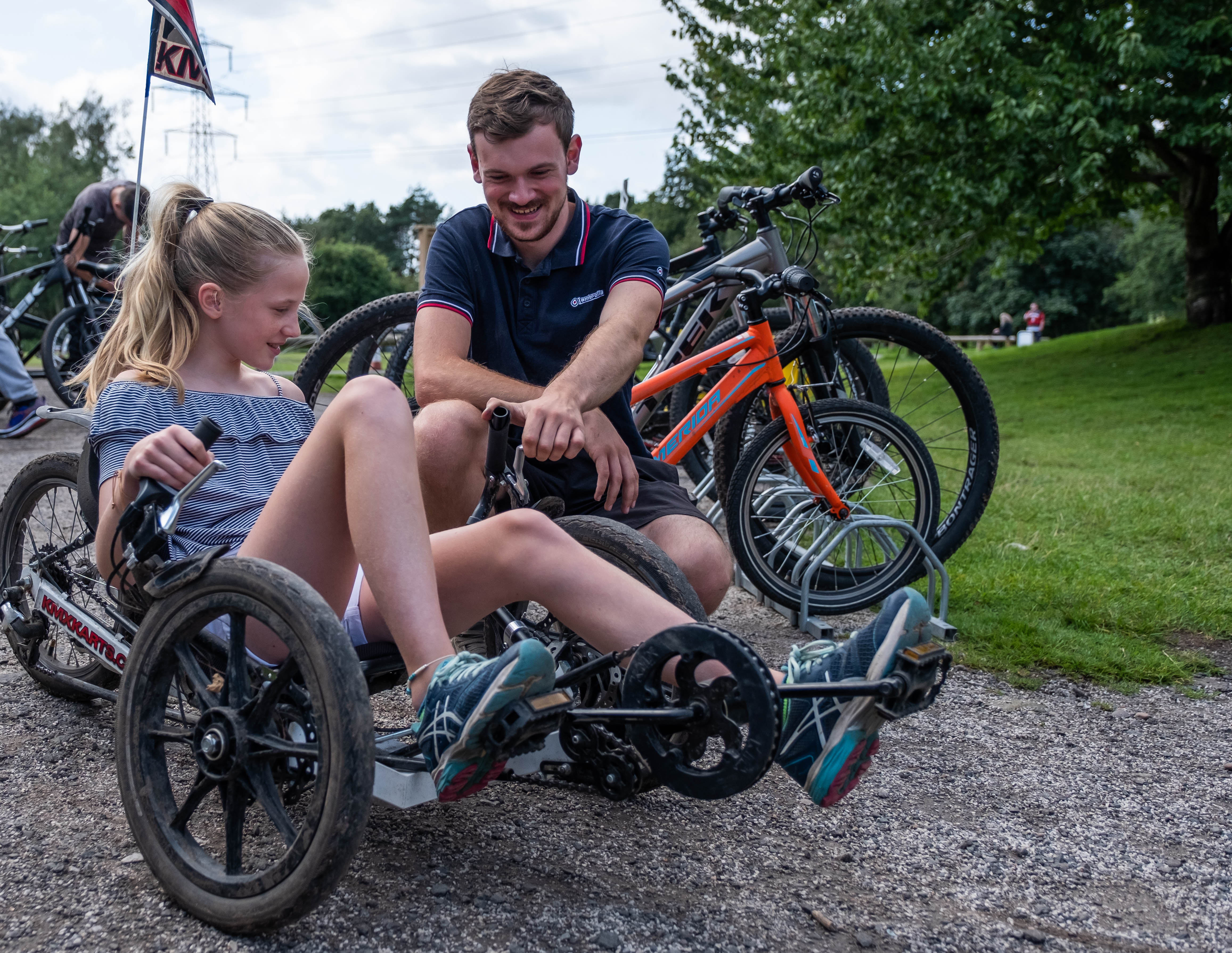 A man shows a girl how to use a KMX Bike at Kingsbury Water Park