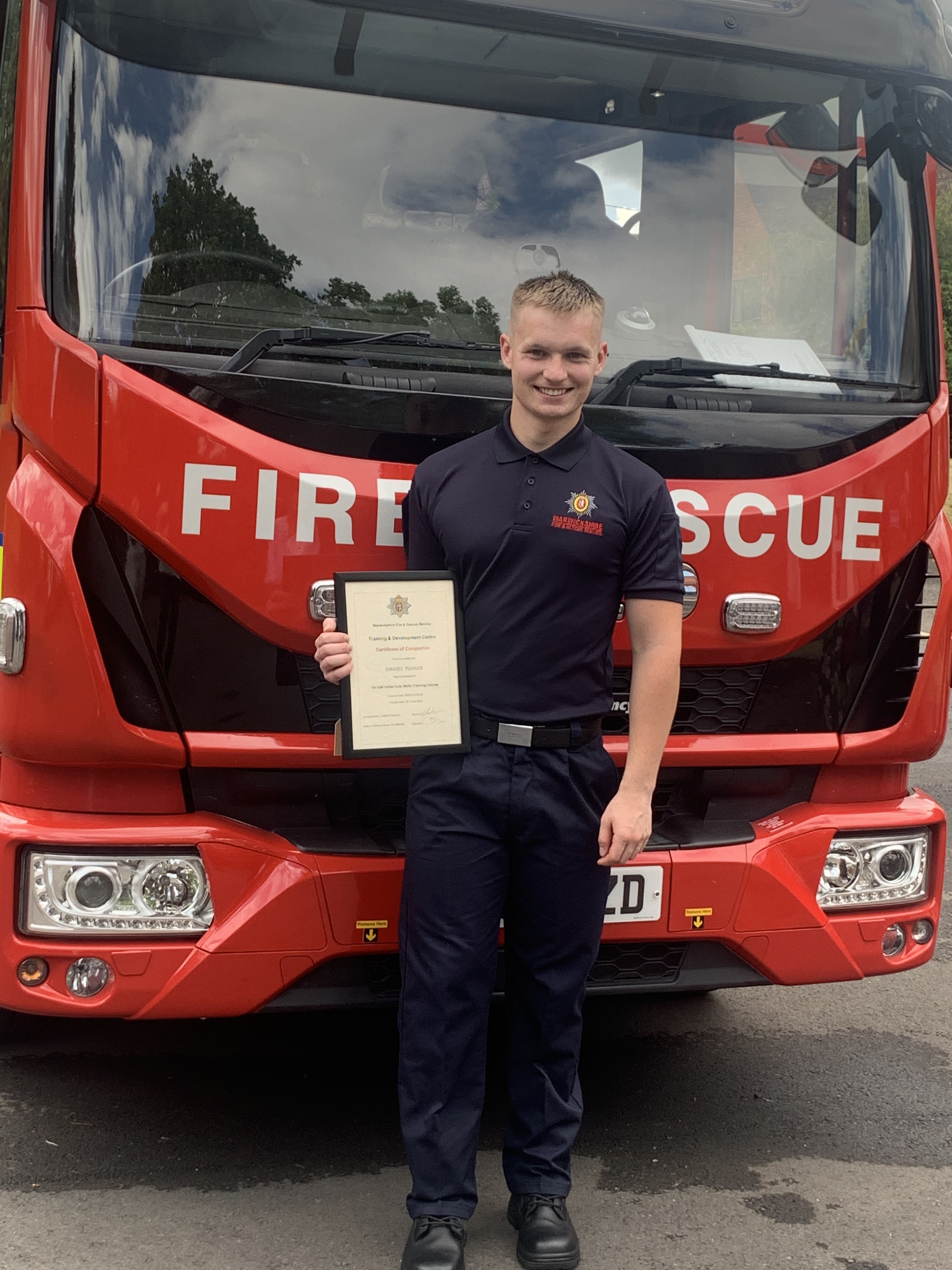 Firefighter Daniel holding certificate