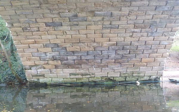 Missing and heavily eroded masonry to underside of the bridge
