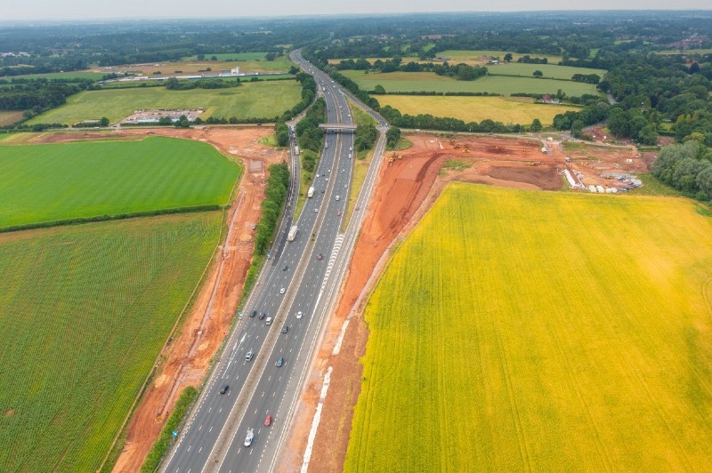 Aerial shot of A46 between green fields with vehicles traveling both ways while works are happening on either side.