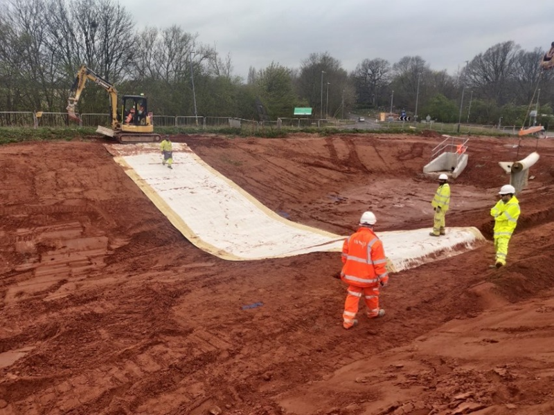 geotextile being installed in retention pond