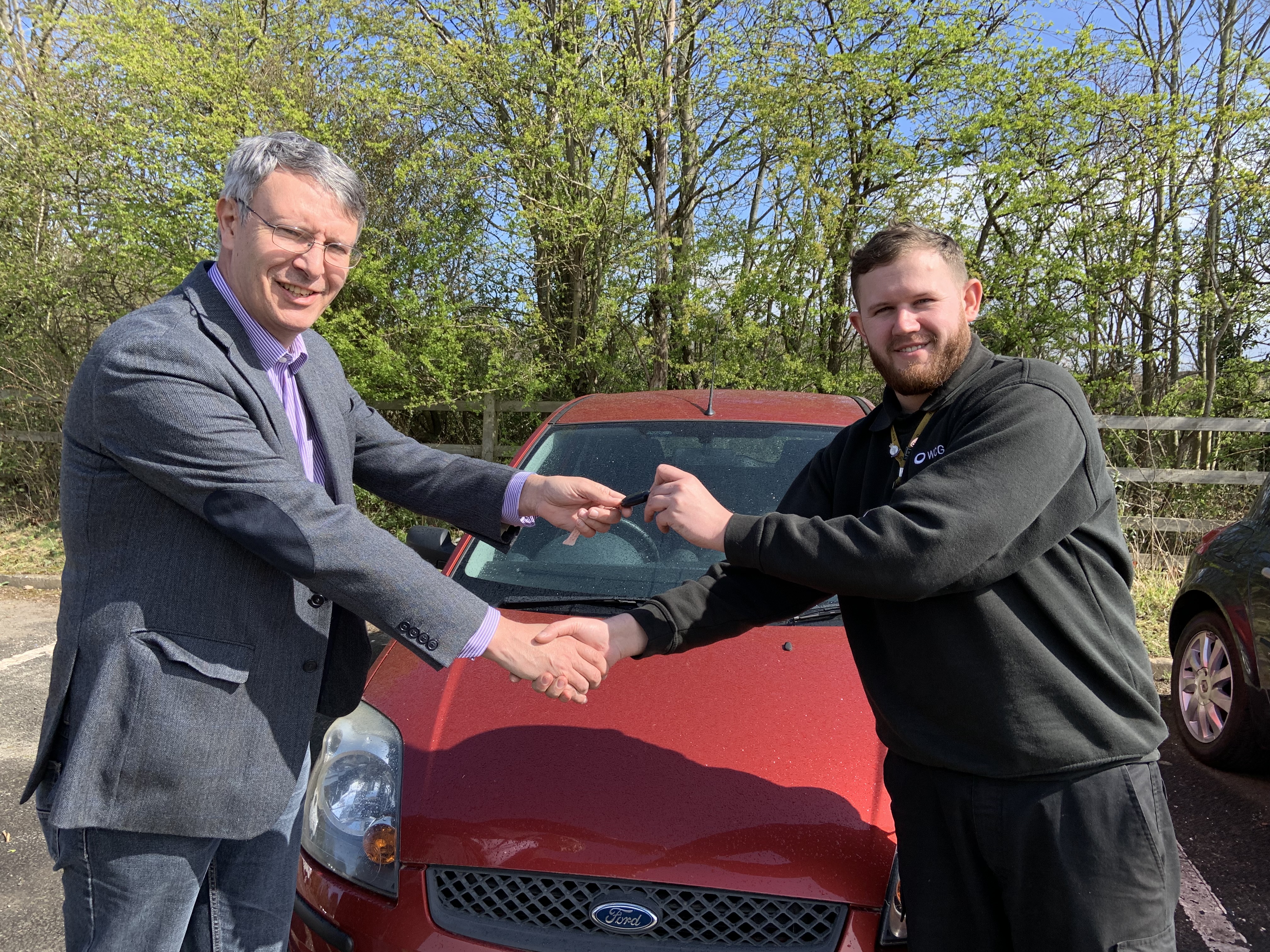 Cllr Andy Crump (left) hands the keys of one of the vehicles to Joshua Saul (right), Motor Vehicle Instructor and Technician at Warwick Trident College.