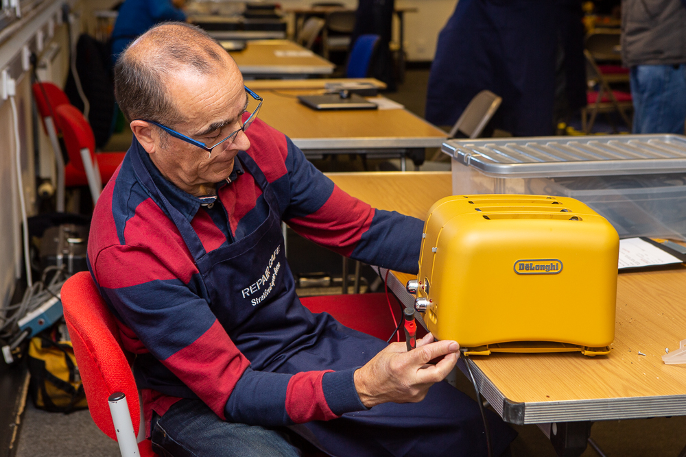 Man working on repairing a toaster.