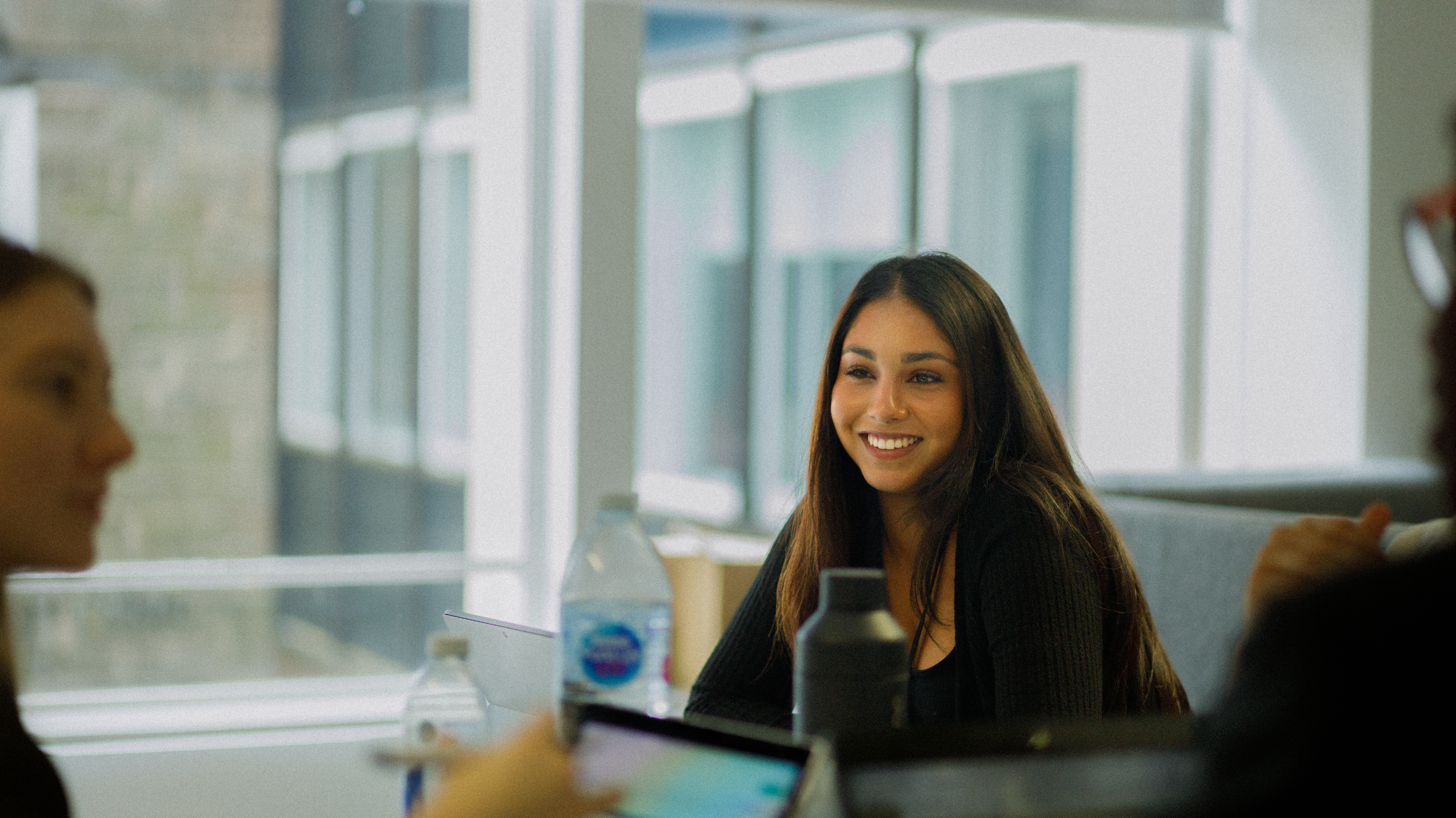 A girl smiling, looking at colleagues