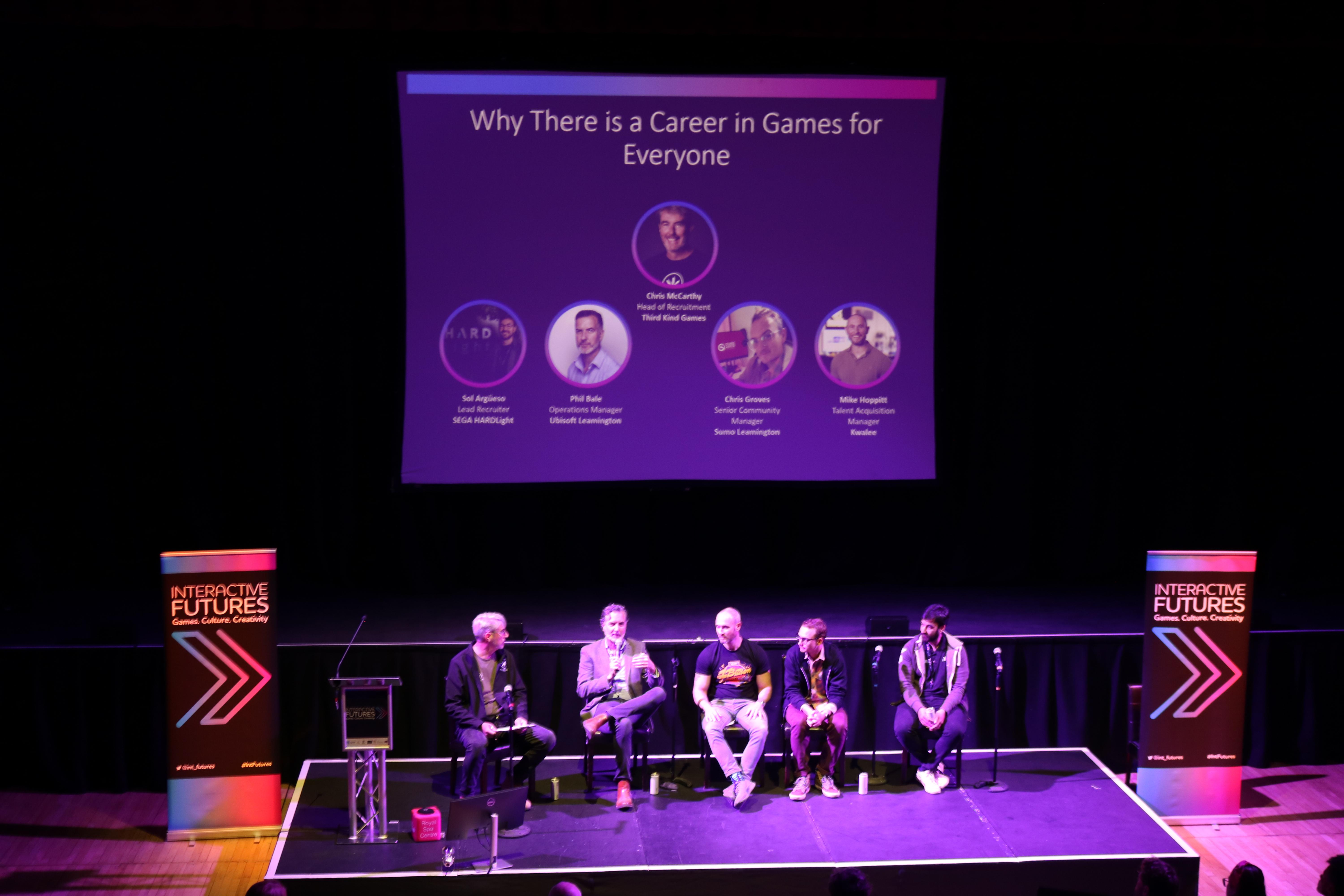 Photograph of a panel on stage at the Interactive Futures event held in May 2023.