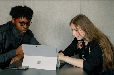 Josh and Olivia working together over a laptop