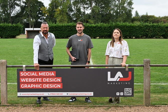 Three people stood in front of a sign that says "LAJ Media: Social Media, Website design, Graphic design".