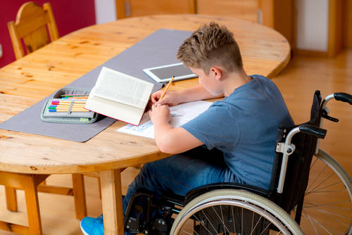 Boy in a wheel chair drawing a picture