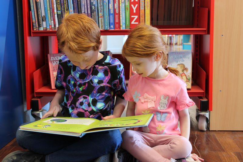 two children reading in a library