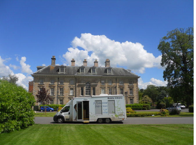 Warwickshire County Council mobile library van parked outside of a building