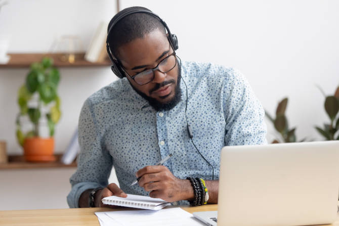 Man making notes from laptop screen