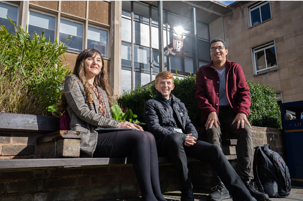 A photo of a group of people sitting outside the Warwickshire County Council building