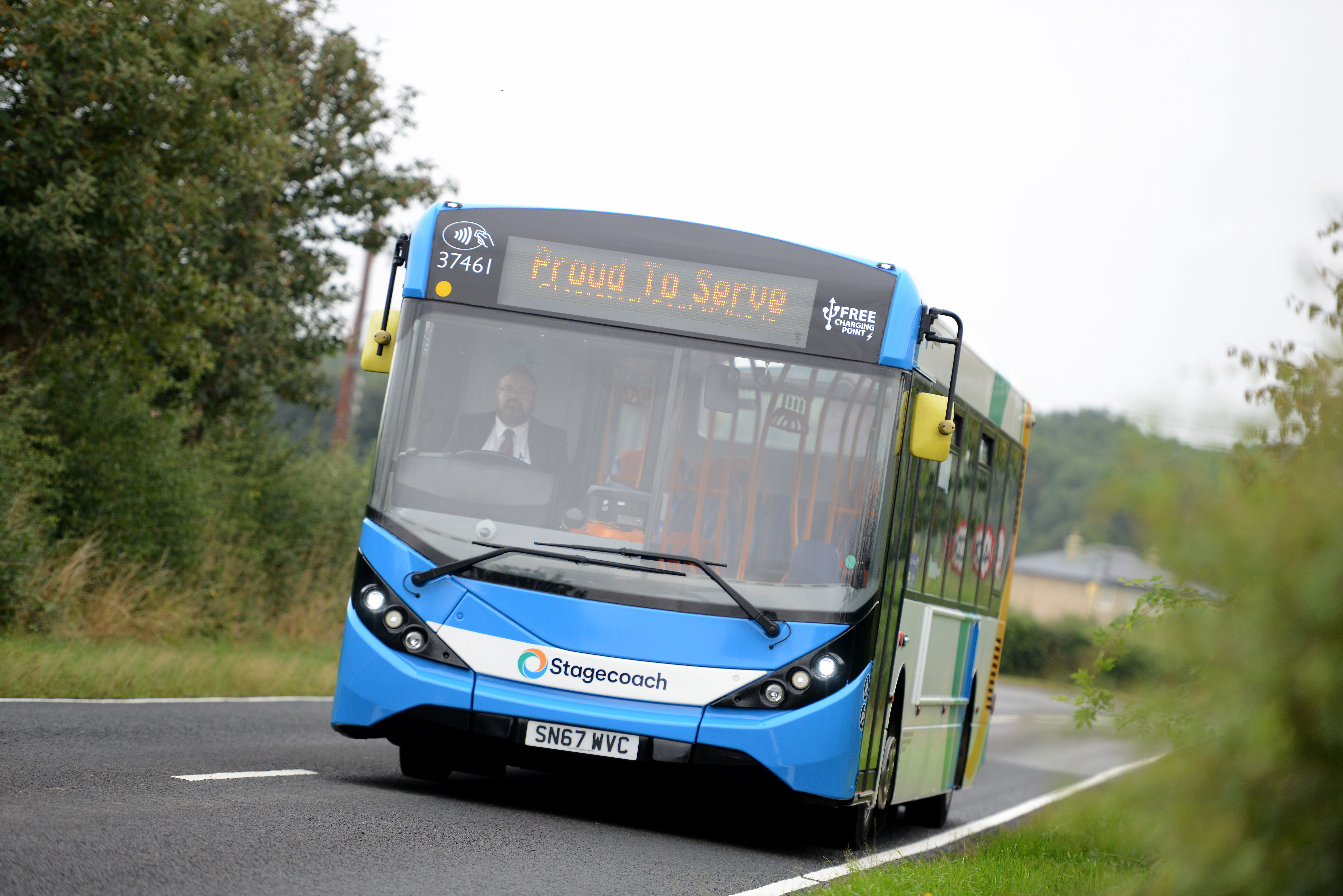 Blue bus travelling along a road