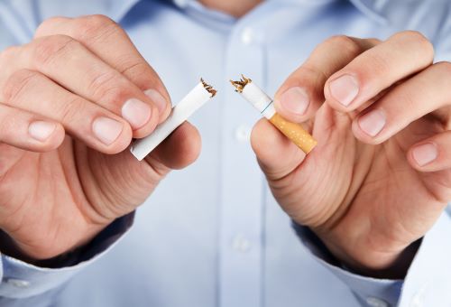 Person breaking cigarette in two