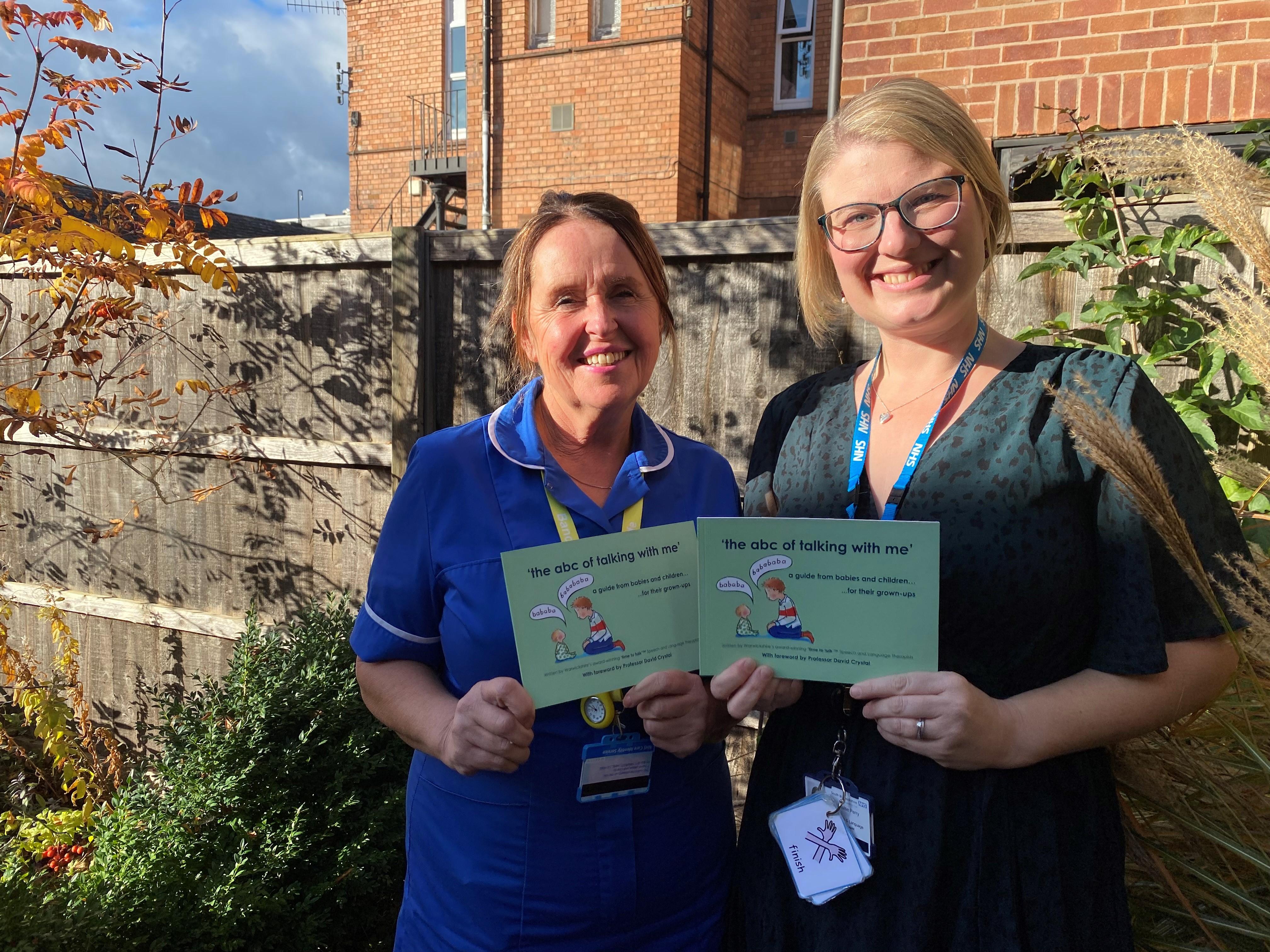 Photograph of two NHS holding books titled "the ABC of talking to me"