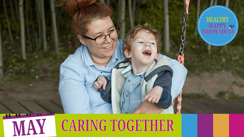 A disabled child in a wheelchair is playing with his mum in the park.
