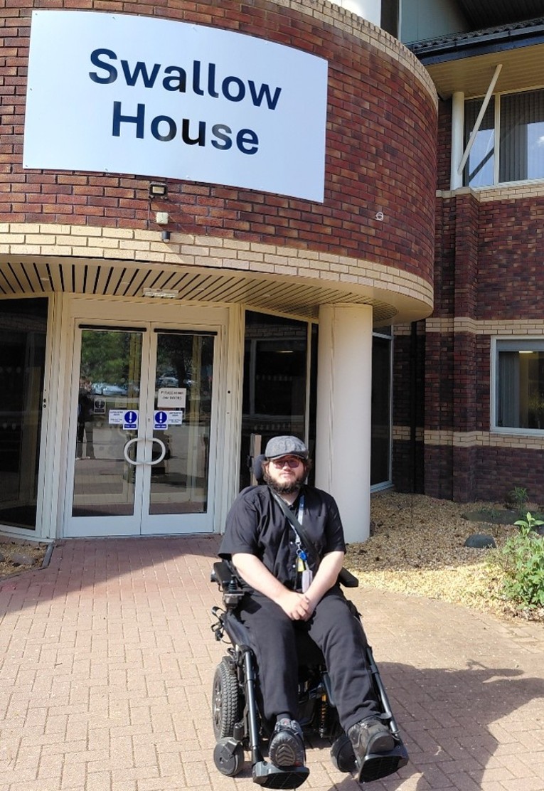 Supported Intern, Ellis, pictured in his wheelchair outside the Swallow House at the University of Warwick