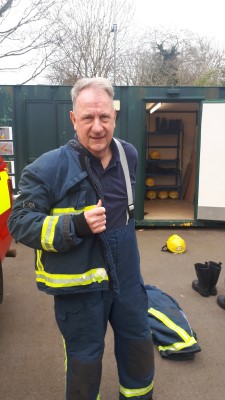 Tony putting on firefighter uniform