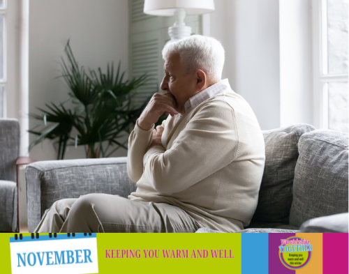 Elderly man sat on sofa looking worried