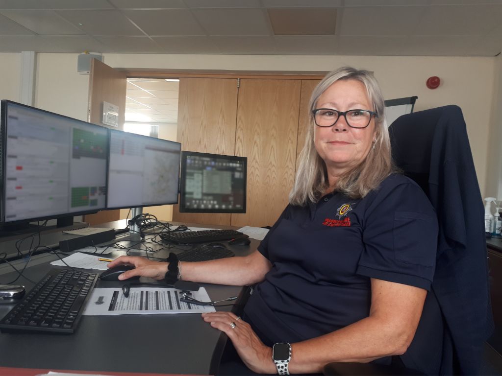 Jayne - Control room firefighter sat at desk with monitors surrounding her