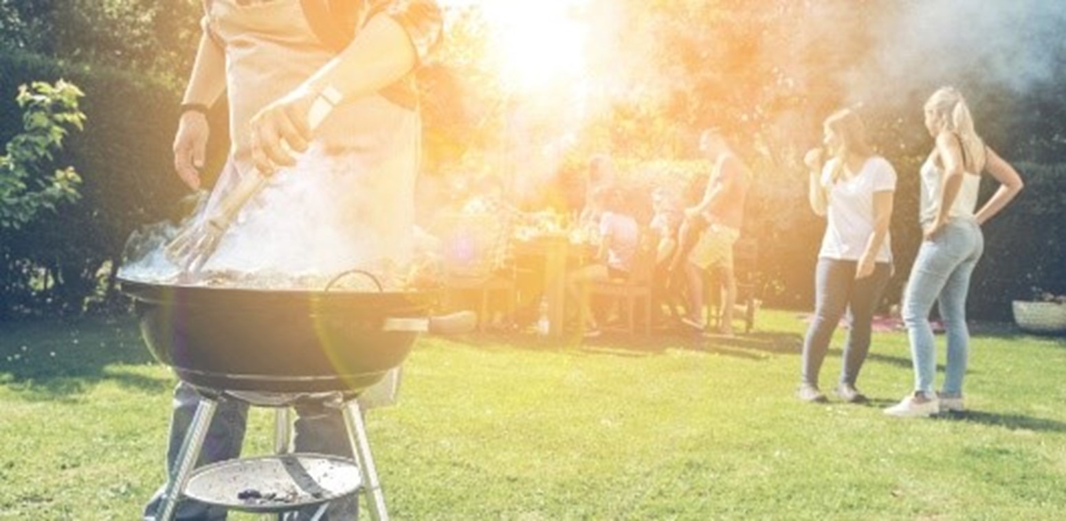People enjoy barbeque in the evening sunshine