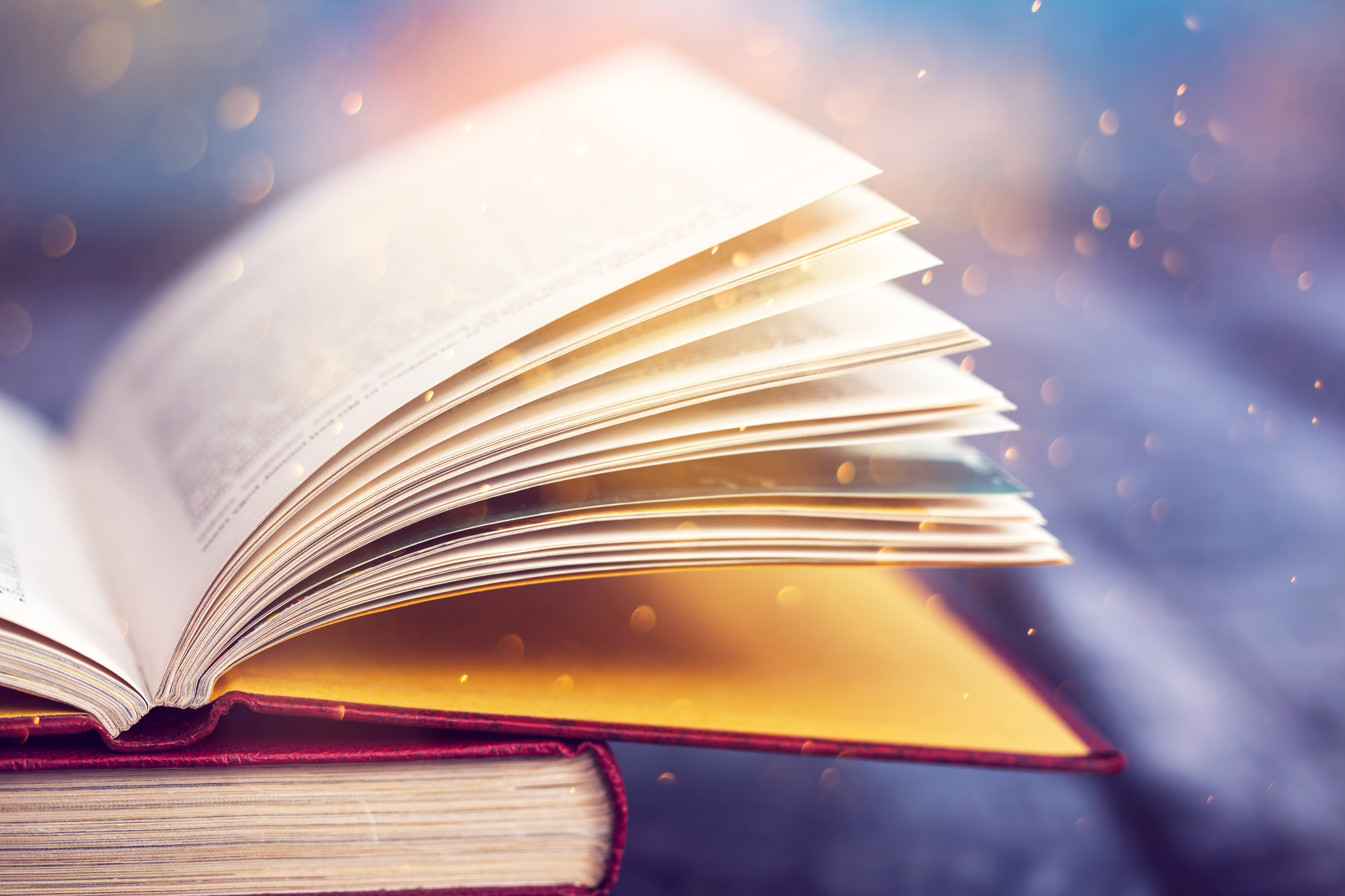 Open book surrounded by sparkles.