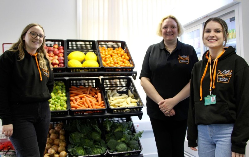 Community pantry - 3 people stood next to display of food