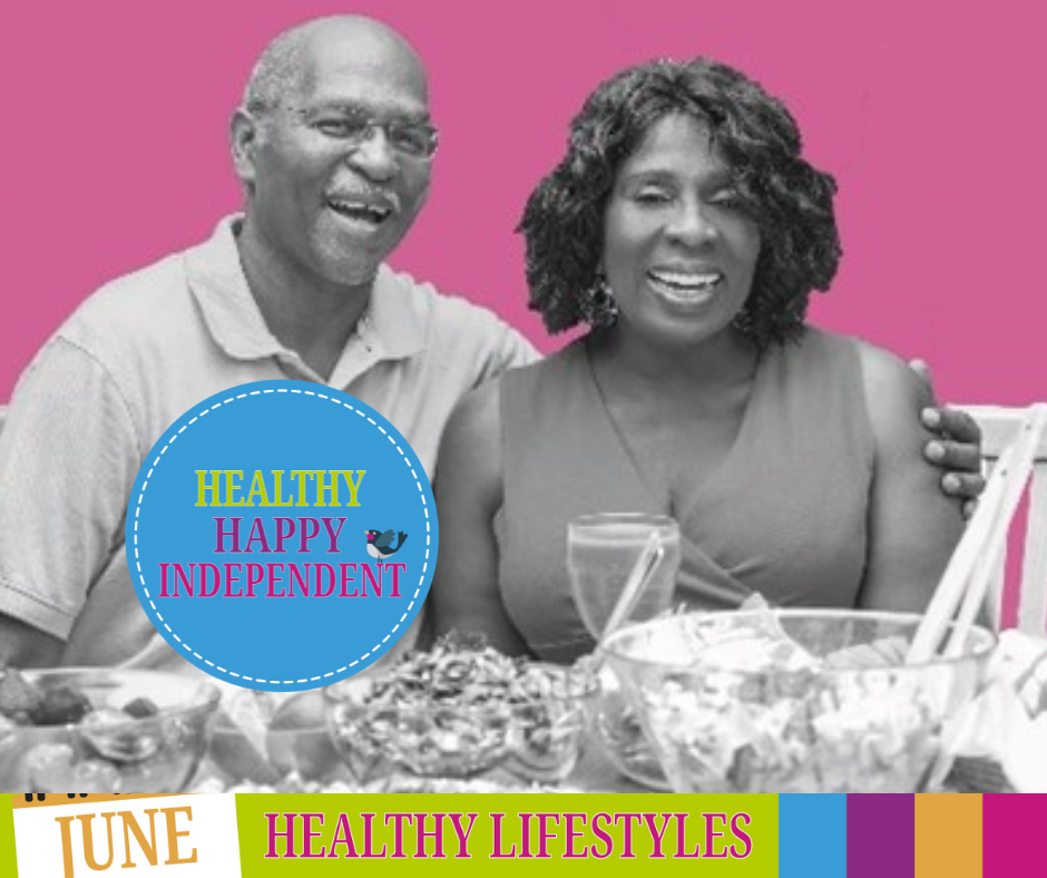 A couple are sat together and in front of them is a table full of healthy food.