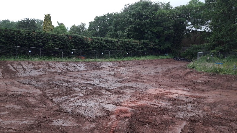 excavated ground, section of soil and grass removed in a path shape.