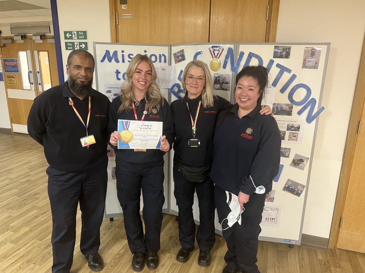 The WFRS Hospital to Home team receive an award - a smiling group of people in uniform with gold medals and a certificate