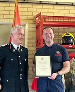 On-call firefighter Ian with Chief Fire Officer Ben Brook holding certificate