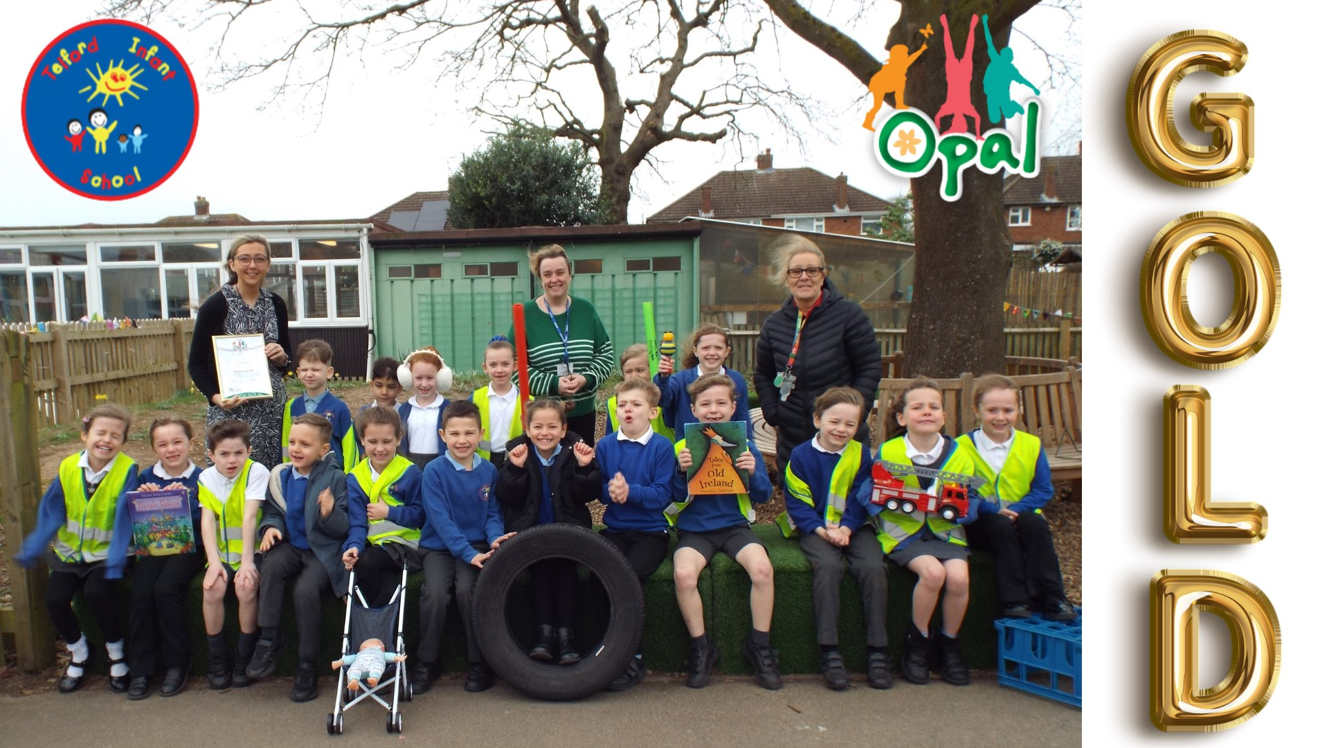 Staff and pupils from Telford Infant School pictured outside on the playground holding their OPAL certificate and with some of the equipment and resources used at play times including a rubber tyre and toy pushchair.
