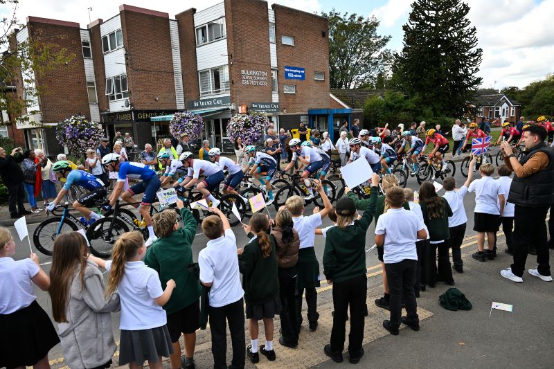 Schoolchildren cheer on the cyclists