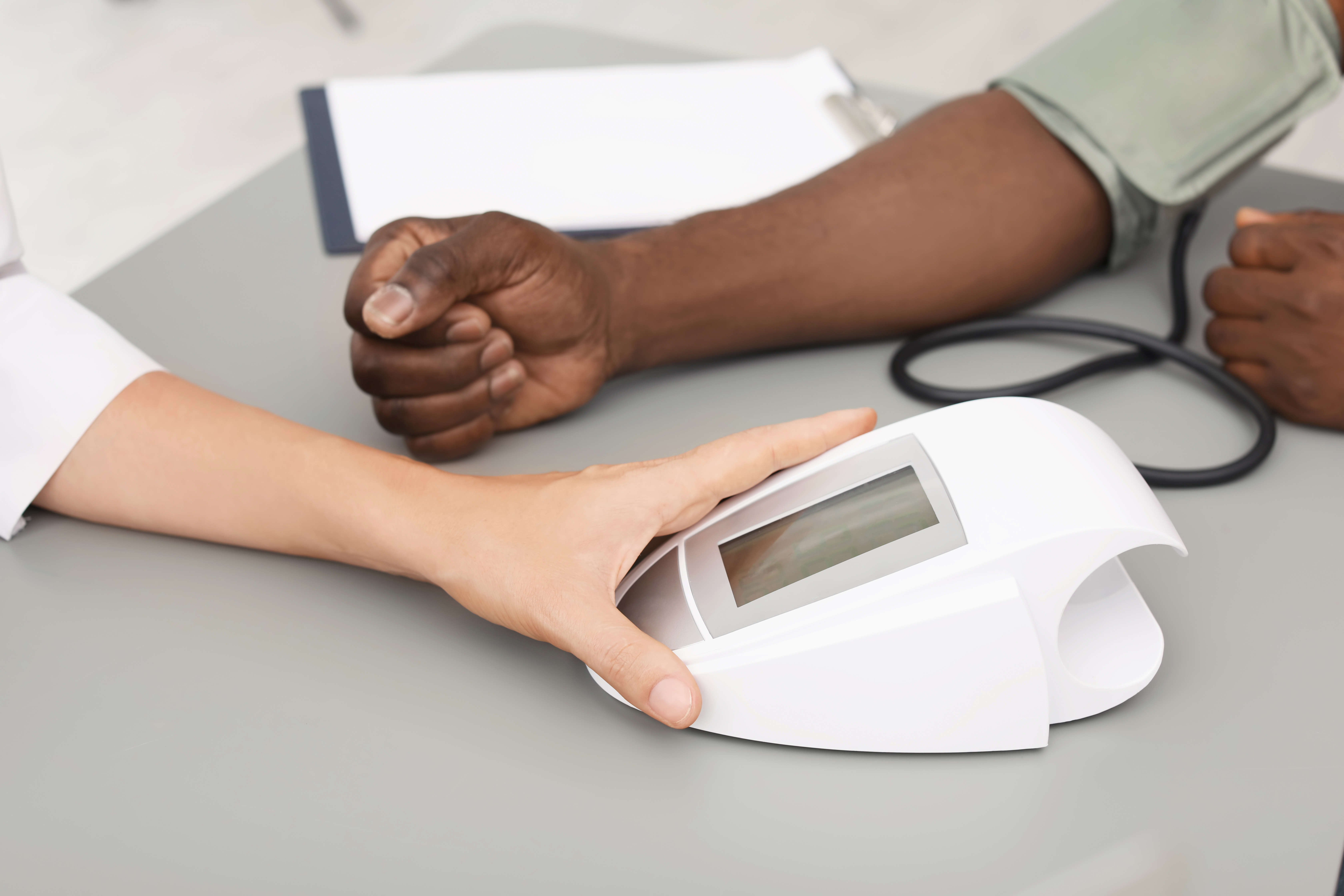 A patient with a medical professional getting their blood pressure taken.