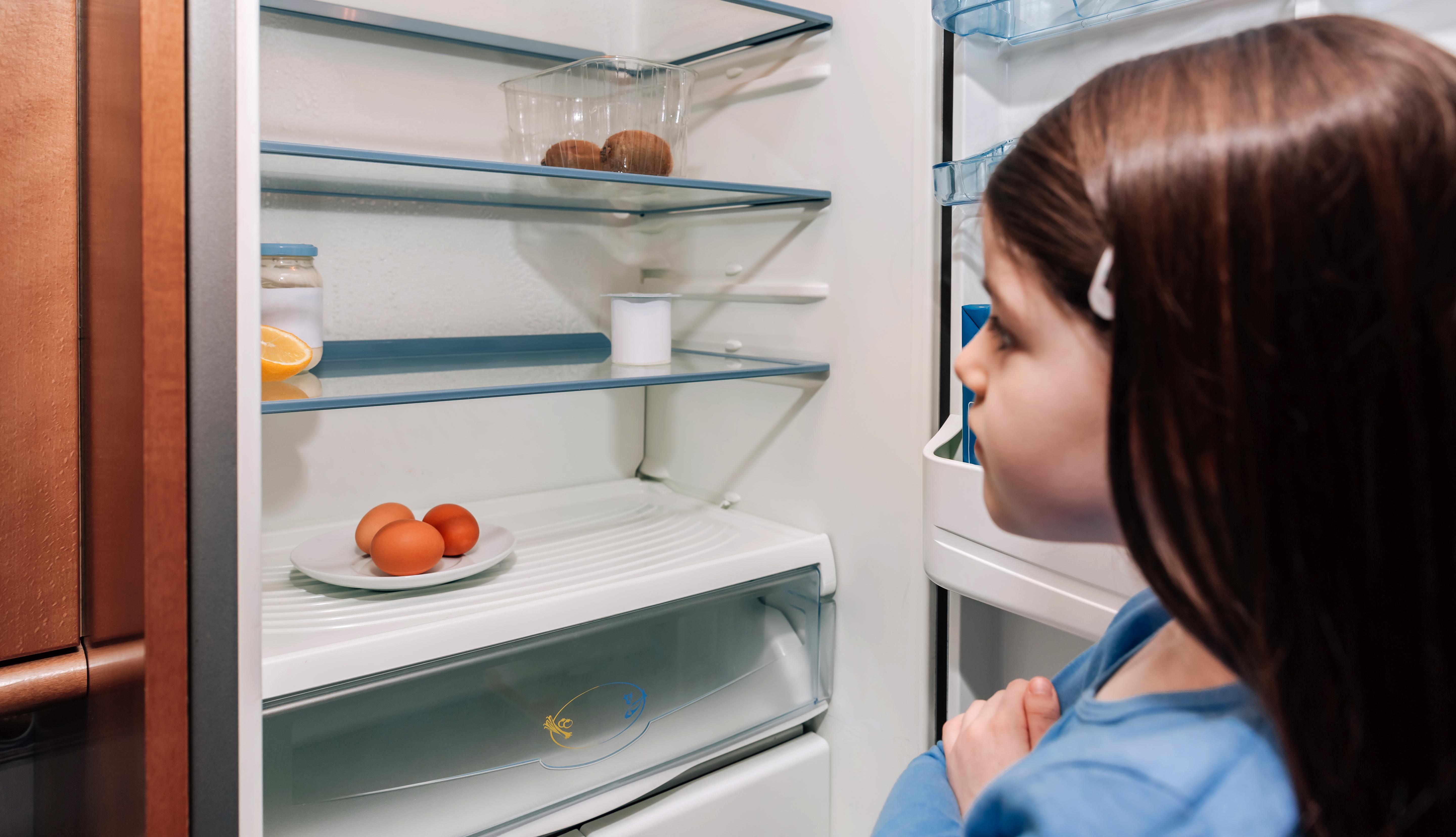 Girl looking into empty fridge