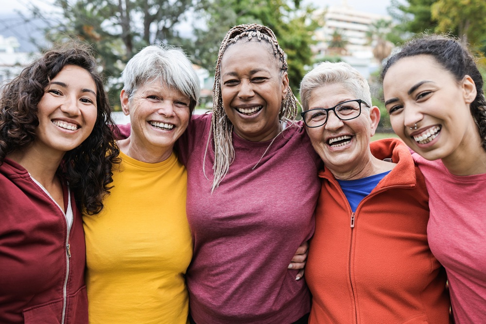 A group of people all stood together in the outdoors and smiling