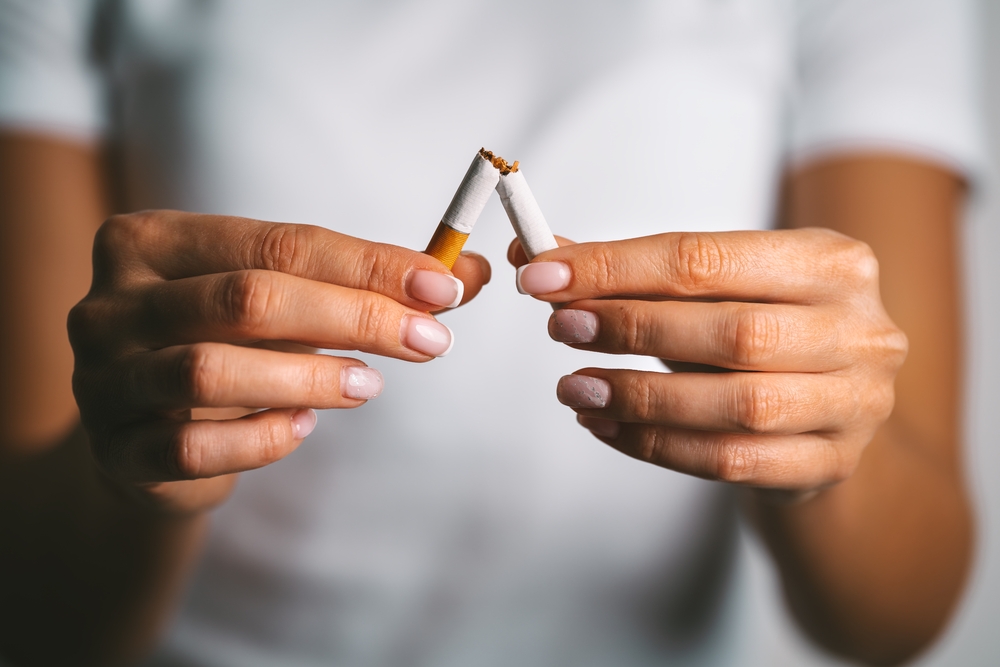 A pair of hands holding a cigarette which has been broken in half