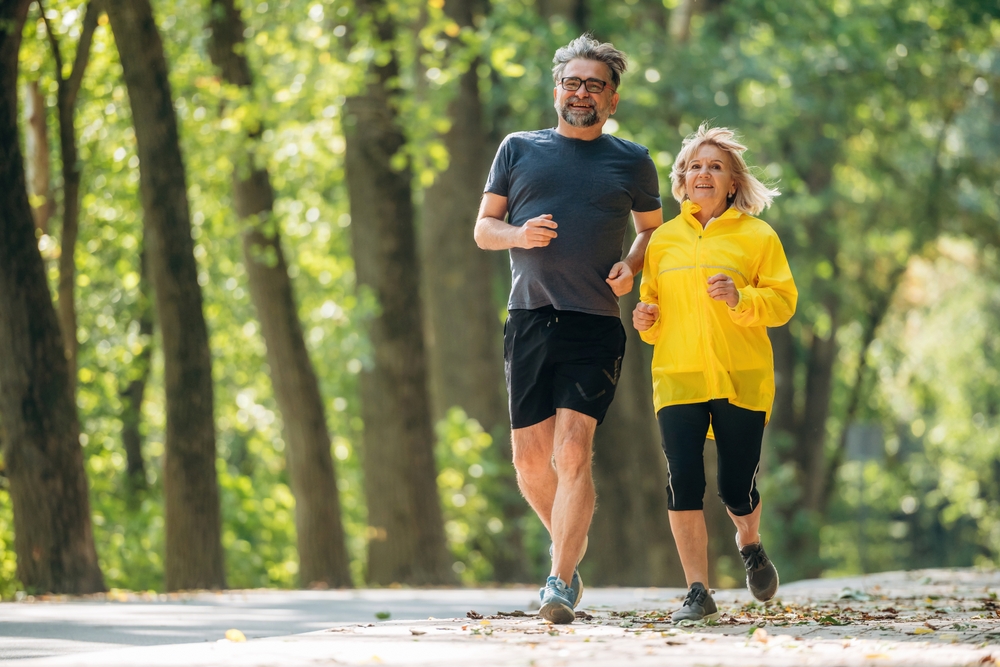 A man and woman running on a park path