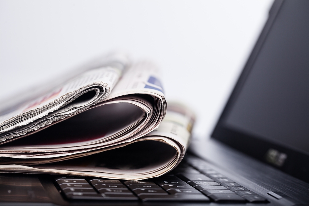 Pile of newspapers on the keyboard of a laptop computer