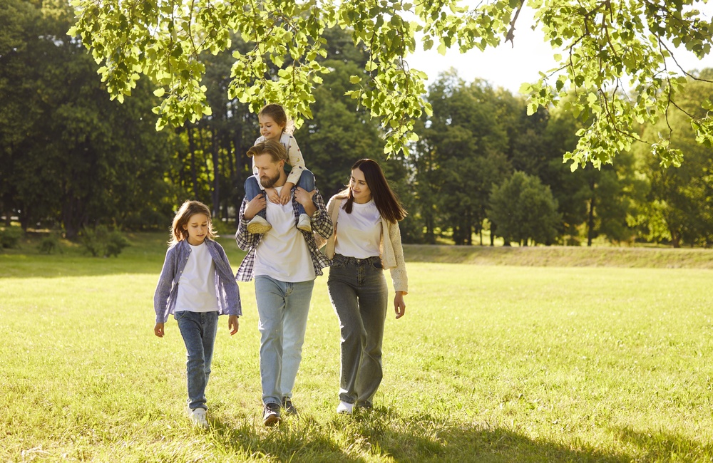 A family walking through a park in the sun