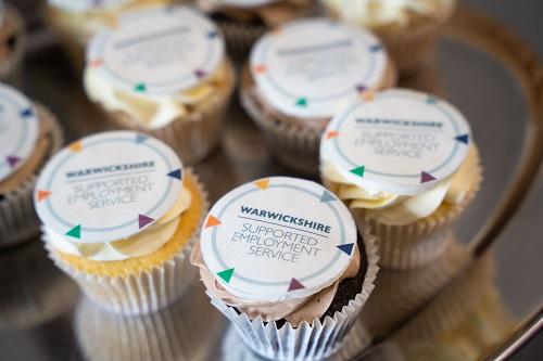 Cupcakes with icing. The text on the icing reads "Warwickshire Supported Employment Service"